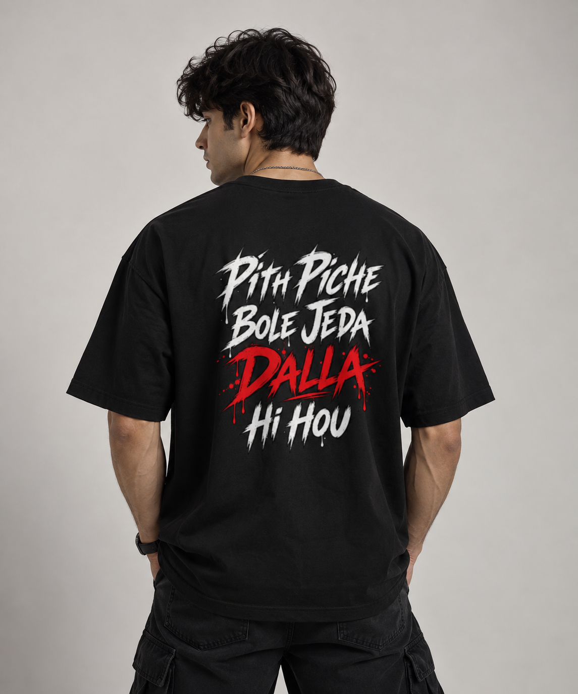 A man wearing a black t-shirt from the back, featuring a bold graphic print in white and red text that reads 'Pith Piche Bole Jeda Bole Joda Hi Hou'.