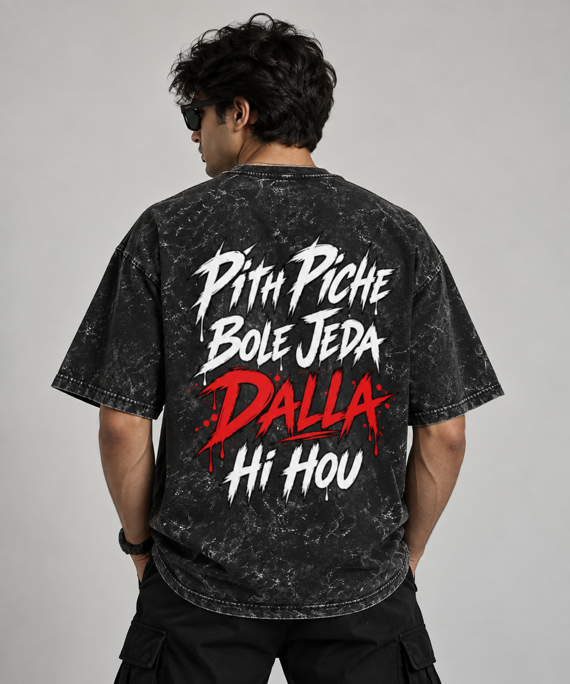 A man wearing a black acid-wash graphic t-shirt with a 'DARE BITE' logo on the chest, paired with black cargo pants and sunglasses, against a solid gray studio background. back side pith piche bole jeda dalla hi hou