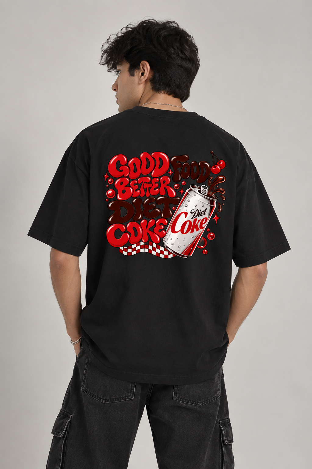 A man wearing a black t-shirt from the back, featuring a large red and white graphic print that reads 'GOOD FOOD BETTER THAN COKE' with a vintage Diet Coke can illustration, set against a plain light gray background.