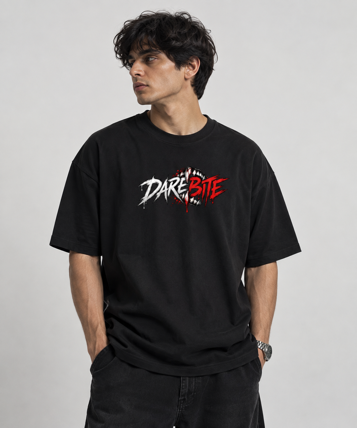 A man wearing a black crewneck t-shirt with a 'DARE BRITE' graphic on the chest, posed against a light gray studio background.