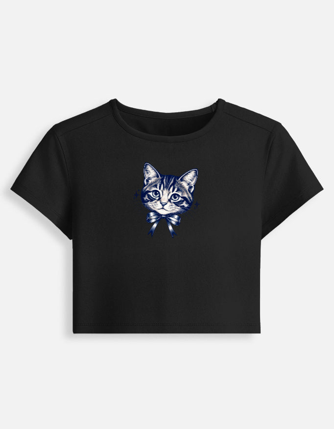 A black short-sleeve crop top t-shirt featuring a blue and white graphic of a tabby cat wearing a bow tie on the center chest, displayed against a light gray background.