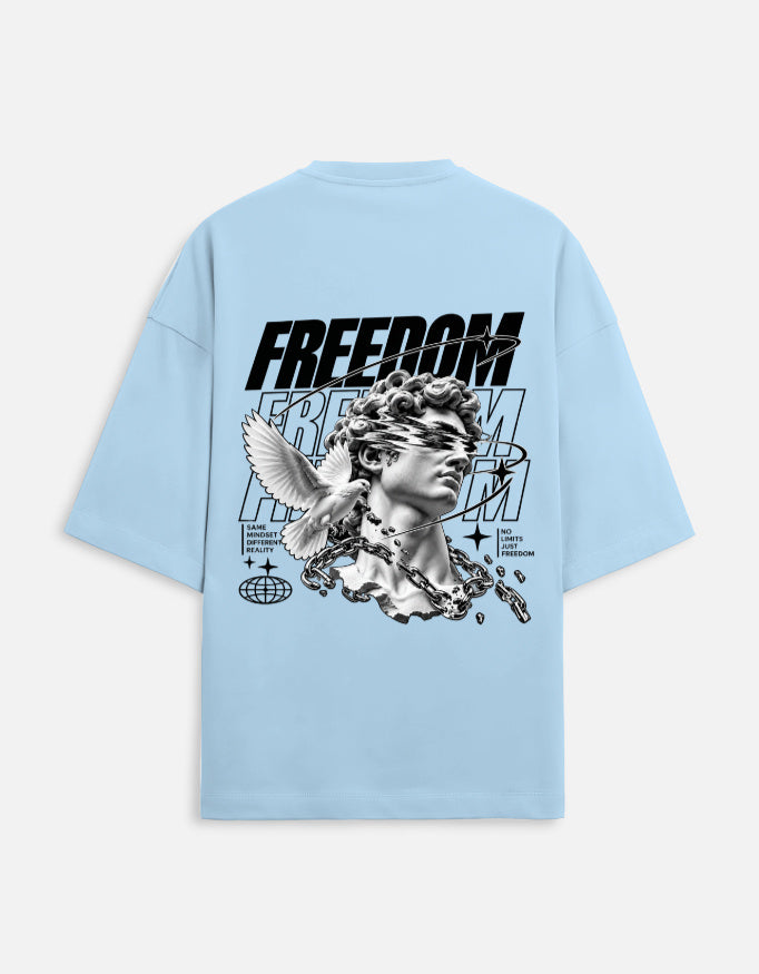 A light blue oversized short-sleeve t-shirt shown from the back, featuring a large black and white graphic print with the word 'FREEDOM' and a classical bust illustration.