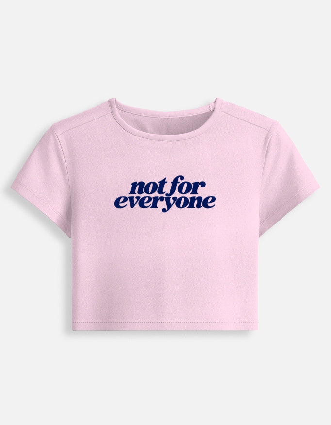 A light pink short-sleeve crop top t-shirt with the text 'not for everyone' printed in navy blue across the chest, displayed on a clean off-white background.