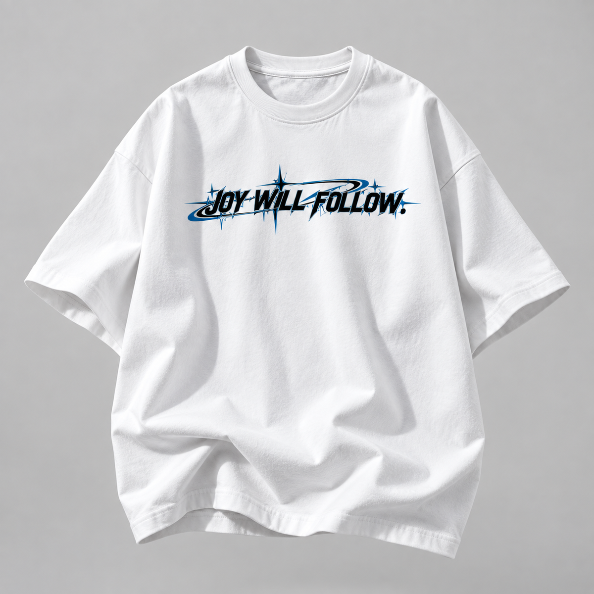 A white short-sleeve t-shirt with a black and blue graphic text reading 'JOY WILL FOLLOW.' across the chest, displayed on a neutral gray background.