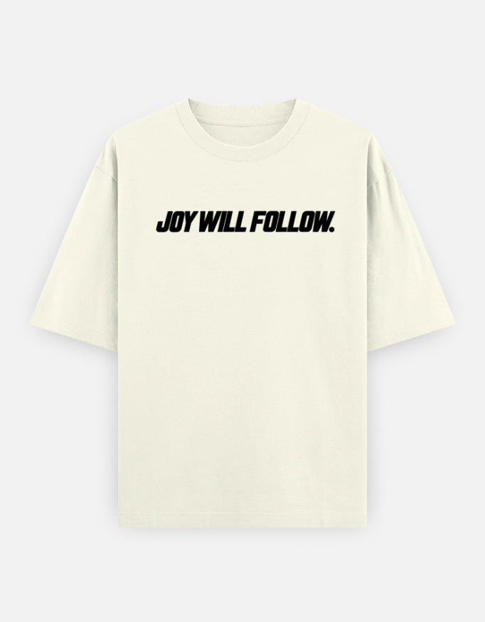 An off-white short-sleeve t-shirt with the phrase 'JOY WILL FOLLOW.' printed across the chest in black italicized text, displayed on a light gray background.